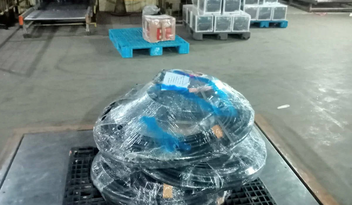 Gulungan kabel elektronik yang dibungkus bubble wrap dan dimasukkan ke dalam plastik, siap untuk dikemas ke dalam kotak.